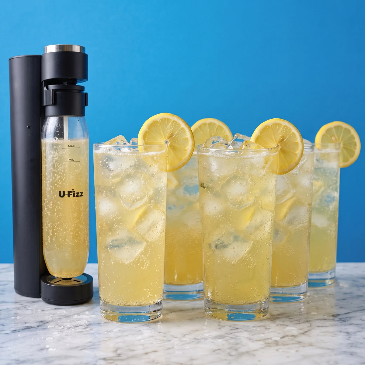 A black U-Fizz carbonator bottle stands on a marble countertop next to four tall glasses filled with Lemon Pub Squash Hard Rated Clone